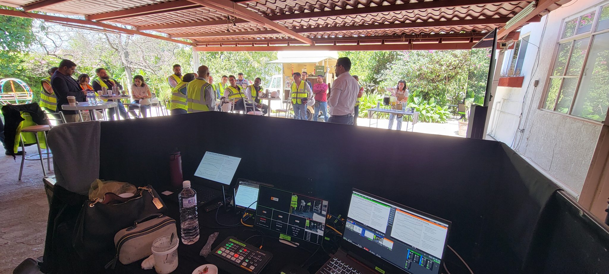 Montaje de producción al aire libre bajo carpa con equipo de control y staff del evento